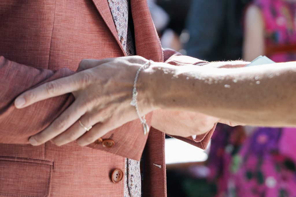 Detailaufnahme wie Braut die Hände des Bräutigam bei seiner Rede hält