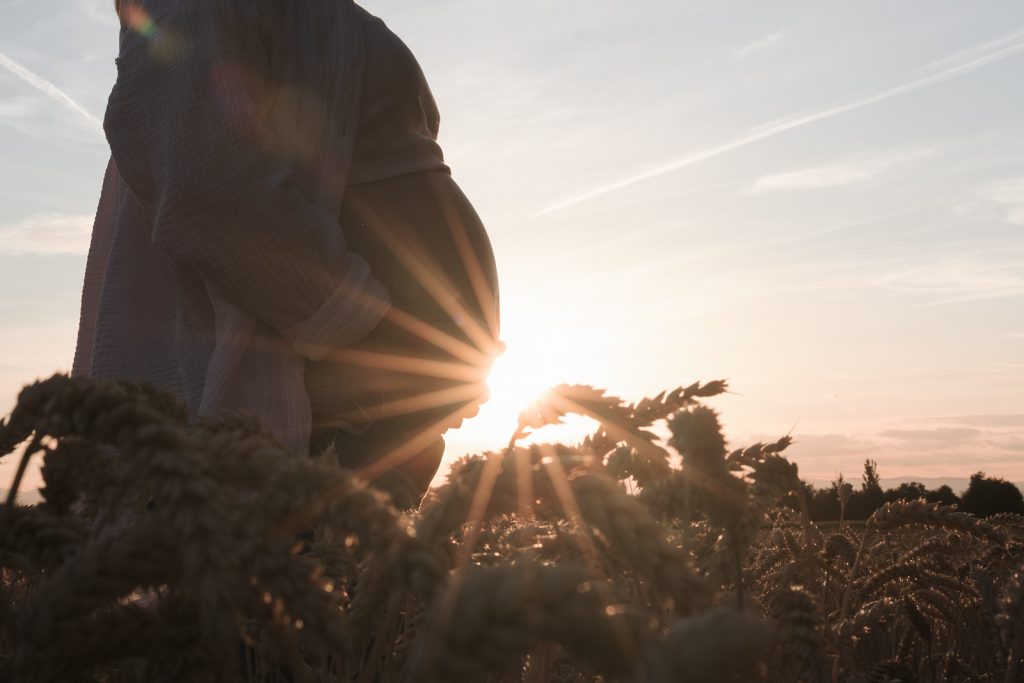 Babybauch im Sonnenuntergang
