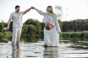 Werdende Eltern tanzen im Wasser